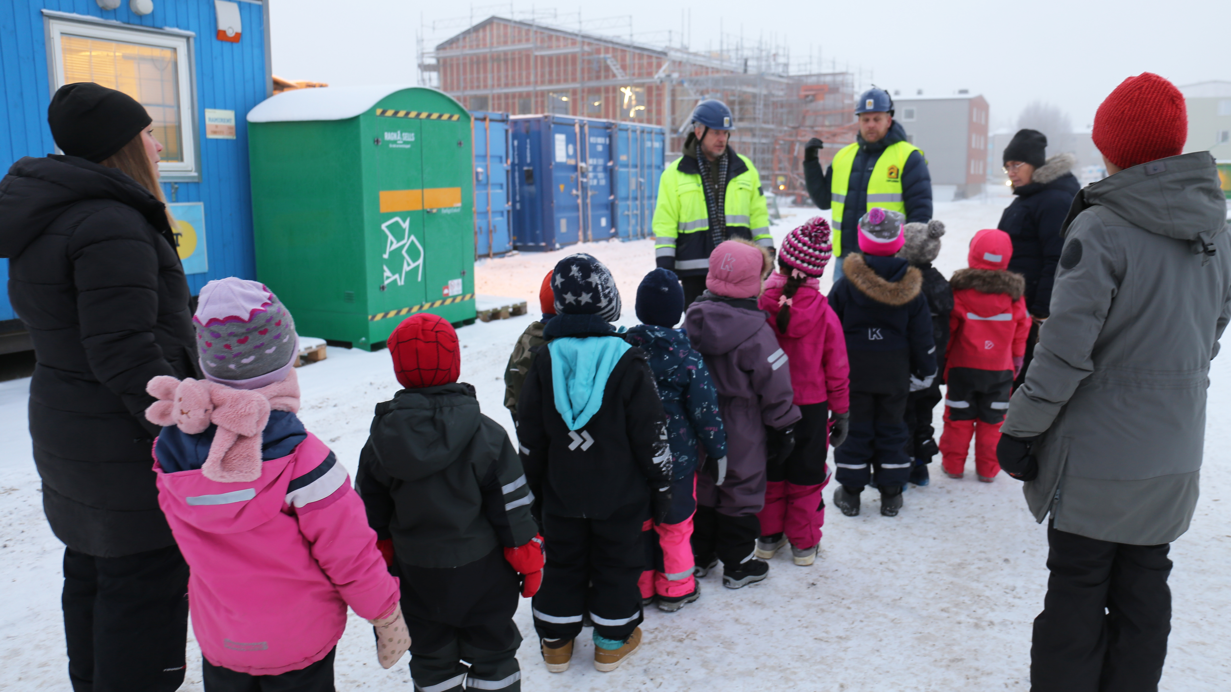 Vintermiljö, barn och personal på väg in i bygget