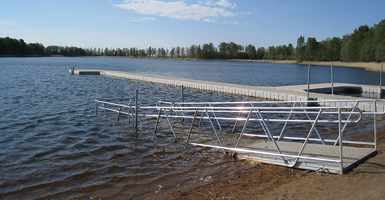 En sjö med både en brygga och en ramp som går ned i vattnet.