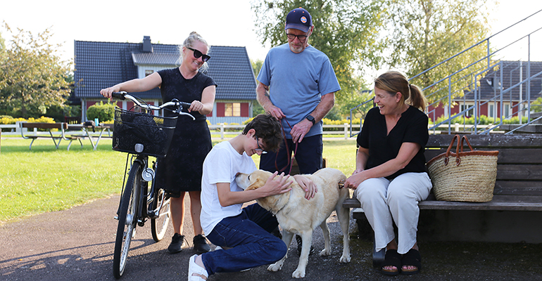 Fyra personer och en hund vid en trappa.