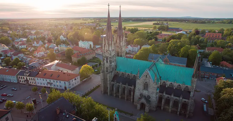 Drönarfoto över Skara centrum där man ser domkyrkan med två torn och grönt koppartak i förgrunden. 