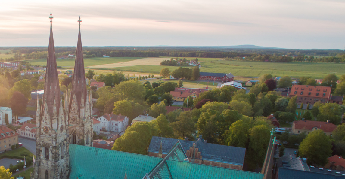 Flygfoto över Skara med domkyrkan i förgrunden med torn och ett grönt tak. 