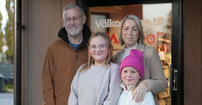 Två kvinnor dricker kaffe vid en lekplats. Ett litet barn sitter på sin mammas arm.