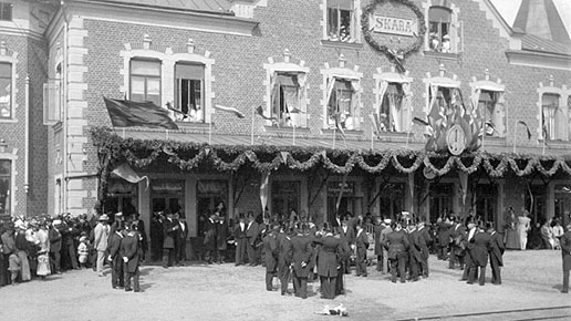 Stationshuset i Skara år 1900. Det vimlar av folk som väntar på kung Oscar II.