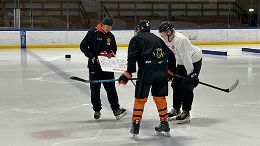 Tränare Emil coacher två av hockeyelever