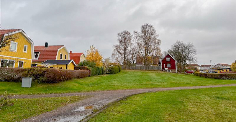 En landsväg, med gula och röda hus till vänster.